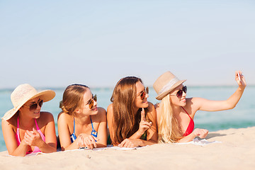 Image showing group of smiling women with smartphone on beach