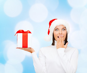 Image showing smiling woman in santa helper hat with gift box