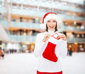 Image showing woman in santa hat with gift box and stocking