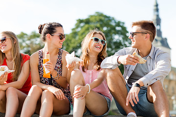 Image showing group of smiling friends sitting on city square