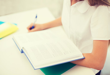 Image showing student girl writing in notebook at school