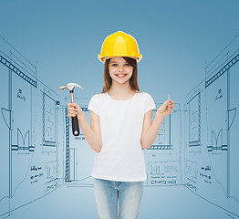 Image showing smiling little girl in hardhat with hammer