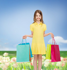 Image showing smiling little girl in dress with shopping bags