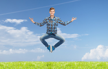 Image showing smiling young man jumping in air