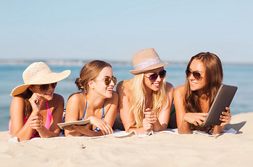 Image showing group of smiling young women with tablets on beach