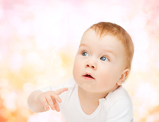 Image showing curious baby lying on floor and looking side