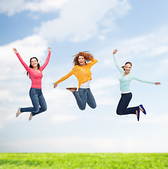 Image showing group of smiling young women jumping in air