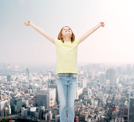 Image showing smiling teenage girl with raised hands