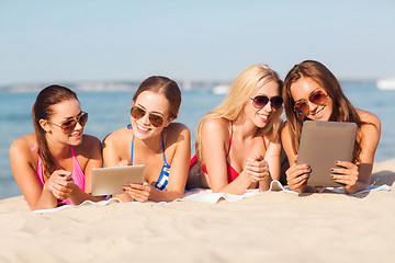 Image showing group of smiling young women with tablets on beach