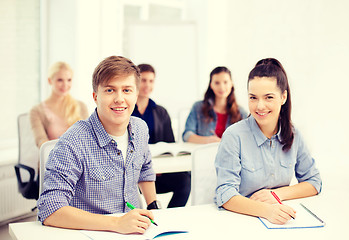 Image showing smiling students with notebooks at school