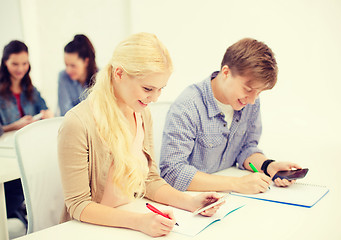 Image showing smiling students with notebooks at school