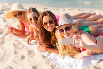 Image showing group of smiling women with smartphone on beach