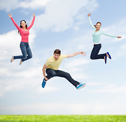 Image showing group of smiling teenagers jumping in air