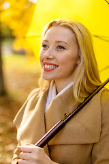 Image showing smiling woman with umbrella in autumn park