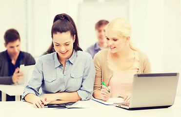 Image showing two smiling students with laptop and tablet pc