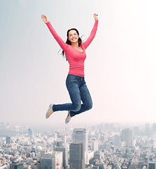 Image showing smiling young woman jumping in air