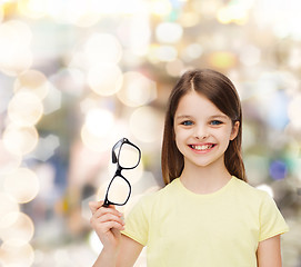 Image showing smiling cute little girl holding black eyeglasses