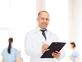 Image showing smiling male doctor with clipboard