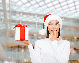 Image showing smiling woman in santa helper hat with gift box