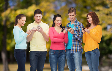 Image showing group of smiling teenagers with smartphones