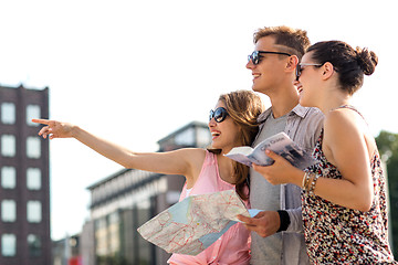 Image showing smiling friends with map and city guide outdoors