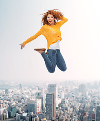 Image showing smiling young woman jumping in air