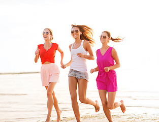 Image showing group of smiling women running on beach