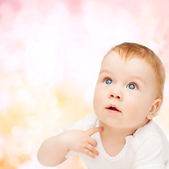 Image showing curious baby lying on floor and looking up