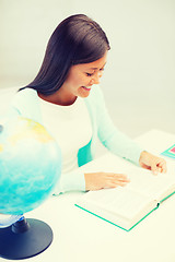 Image showing female teacher with globe and book