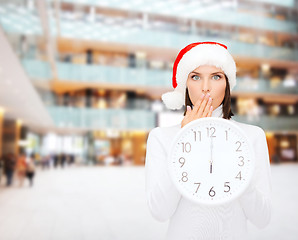 Image showing woman in santa helper hat with clock showing 12