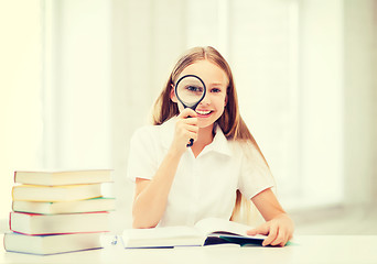 Image showing girl reading book with magnifier at school