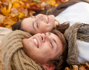 Image showing close up of smiling couple lying in autumn park