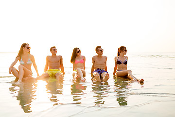 Image showing smiling friends in sunglasses on summer beach