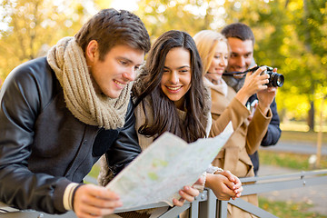 Image showing group of friends with map and camera outdoors