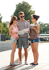 Image showing smiling friends with map and city guide outdoors