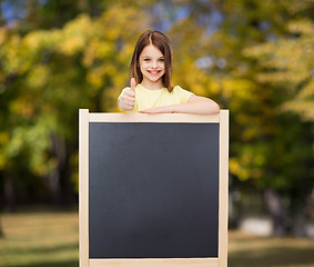 Image showing happy little girl with blank blackboard