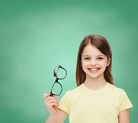 Image showing smiling cute little girl holding black eyeglasses