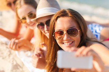 Image showing close up of smiling women with smartphone on beach