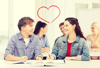 Image showing two teenagers with notebooks and book at school