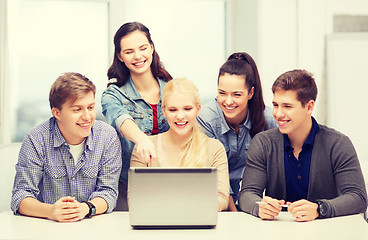 Image showing smiling students looking at laptop at school