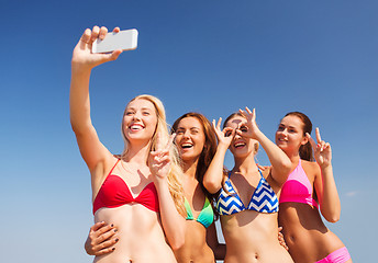 Image showing group of smiling women making selfie on beach