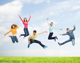 Image showing group of smiling teenagers jumping in air