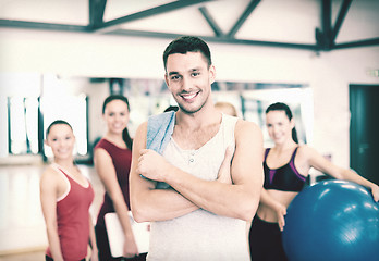 Image showing smiling man standing in front of the group in gym