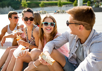 Image showing group of smiling friends sitting on city square