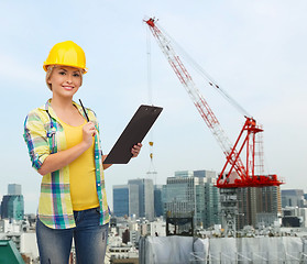 Image showing smiling woman in helmet with clipboard