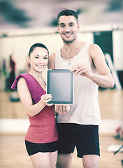 Image showing two smiling people showing blank tablet pc screen