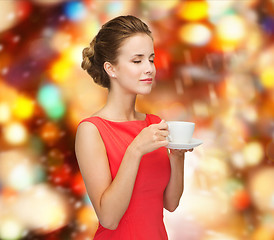 Image showing smiling woman in red dress with cup of coffee