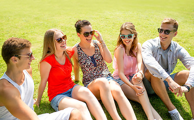 Image showing group of smiling friends outdoors sitting in park