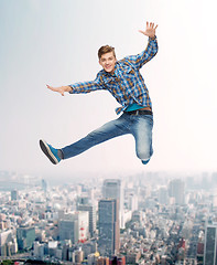 Image showing smiling young man jumping in air