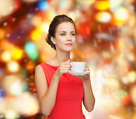 Image showing smiling woman in red dress with cup of coffee